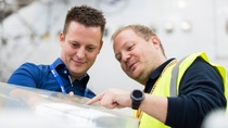 A BASF worker and a Lufthansa Technik worker stand together, looking at and discussing a piece of the new sharkskin film. (Photo: Lufthansa Cargo) A BASF worker and a Lufthansa Technik worker stand together, looking at and discussing a piece of the new sharkskin film. (Photo: Lufthansa Cargo)