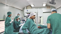 Several people in scrubs in an operating room.