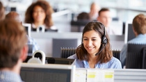 Young woman working in call centre, surrounded by colleagues Young woman working in call centre, surrounded by colleagues