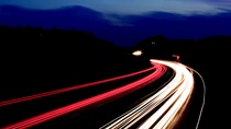 long exposed image of highway at night with red and yellow lines 