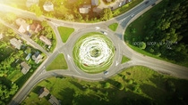 Aerial view of a grassy roundabout with four exits, surrounded by trees and green fields - scientific equations and sketches highlighting the flow of traffic are overlaid on the picture.