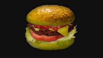 Image of a burger in front of a black background.