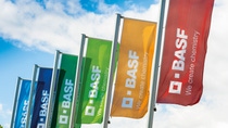 Six colorful BASF flags which bear the slogan "We create chemistry." are fluttering in the wind. The sky is blue. Six colorful BASF flags which bear the slogan "We create chemistry." are fluttering in the wind. The sky is blue.