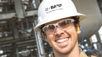 BASF engineer is white hard hat and safety goggles laughing BASF engineer is white hard hat and safety goggles laughing