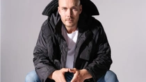 A man models a stylish black casual jacket crafted from recycled materials. A man models a stylish black casual jacket crafted from recycled materials.