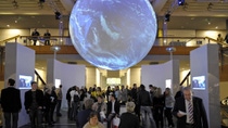  exhibit space with projected earth hanging above crowd