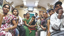 Several people sit waiting in a train compartment.