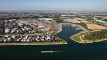 The picture shows an aerial view of a sprawling industrial and port landscape on a large river.