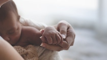 Close up Mother holding hands Asian female newborn baby  and sunlight in the morning. Cute little girl  three weeks old. Health, care, love, relationship concept.