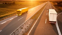 Yellow and white truck in motion blur on the highway at sunset Yellow and white truck in motion blur on the highway at sunset