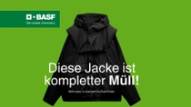 Eine Schwarze Jacke vor grünem Hintergrund. Der Text lautet: "Diese Jacke ist kompletter Müll!"