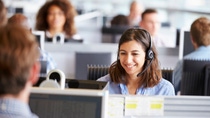 Young woman working in call centre, surrounded by colleagues Young woman working in call centre, surrounded by colleagues