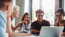 University students sitting together at table with books and laptop. Happy young people doing group study in library.; Shutterstock ID 508251865