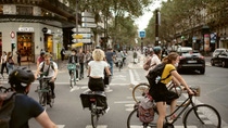 Many cyclists riding through a crossing in Paris.