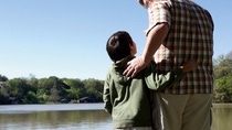Man and boy standing at a lake Man and boy standing at a lake