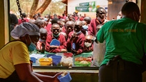 Two women from the food bank hand students their lunch. Two women from the food bank hand students their lunch.