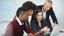 Cropped shot of a group of businesspeople discussing something on a laptop Cropped shot of a group of businesspeople discussing something on a laptop