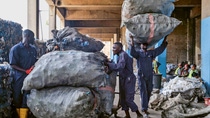 Three men piling and carrying large bags of plastic bottles. Three men piling and carrying large bags of plastic bottles.