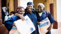 Three happy women wearing blue robes hold basf packages Three happy women wearing blue robes hold basf packages