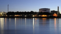 view of BASF production buildings by the water at sunset