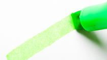 Green highlighter making a line on white paper