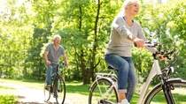 Senior Couple Riding Bikes In Park