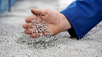Aufgeschäumtes Neopor® ist federleicht: Mit einem Griff in die silbergrauen Kugeln kontrolliert ein Mitarbeiter das Ergebnis des Vorschäumens.      Abdruck honorarfrei. Copyright by BASF.Foamed Neopor® is as light as a feather: an operator feels the silver-gray beads to check the results of the prefoaming process.       Print free of charge. Copyright by BASF.
