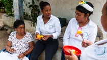 3 women sitting around each other, eating fruit. 3 women sitting around each other, eating fruit.