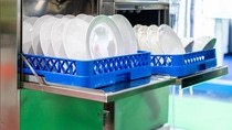 close up white plate on basket in automatic dishwasher machine for industrial