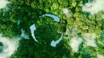 Aerial view of a lush green forest with wisps of cloud and three narrow lakes shaped like a circle of three arrows to symbolize recycling. Aerial view of a lush green forest with wisps of cloud and three narrow lakes shaped like a circle of three arrows to symbolize recycling.