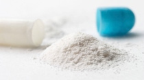 Close up of a pill with blue cap with small mountain of white powder Close up of a pill with blue cap with small mountain of white powder