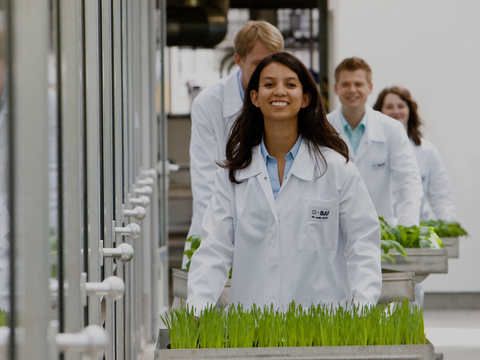 A smiling young woman in laboratory clothing.