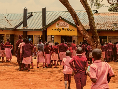Die Schüler stehen an, um sich ihr Mittagessen aus der Food4Education-Küche abzuholen.