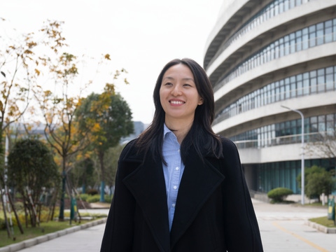 A woman walking towards the camera and smiling