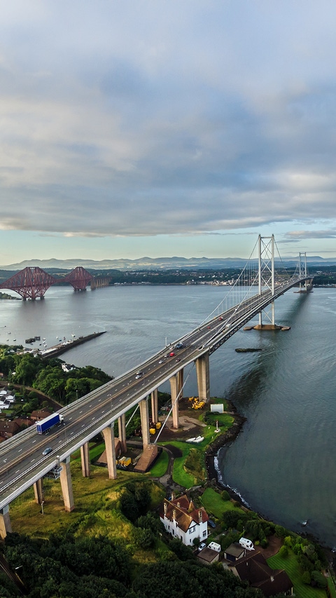 The new Queensferry Crossing bridge (on the right) under construction over the Firth of Forth with the older Forth Road bridge (on the left) and with the iconic Forth Rail Bridge in the far left. The new Queensferry Crossing bridge (on the right) under construction over the Firth of Forth with the older Forth Road bridge (on the left) and with the iconic Forth Rail Bridge in the far left.