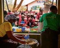 Zwei Frauen von der Essensausgabe reichen den Schülern ihr Mittag.