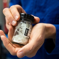Bernhard holds a glass with recycled glass fibers.