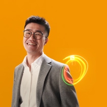A male BASF employee in a suit standing against an orange background, a light swirl hovers around his shoulder. A male BASF employee in a suit standing against an orange background, a light swirl hovers around his shoulder.