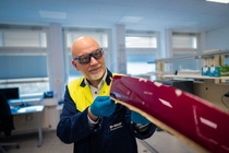 Patrick Keil inspects a painted workpiece in the laboratory.