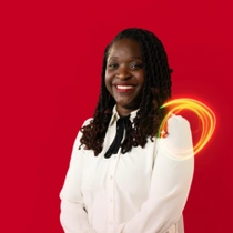 A female BASF employee in a white shirt standing against a red background, a light swirl hovers around the shoulder. A female BASF employee in a white shirt standing against a red background, a light swirl hovers around the shoulder.